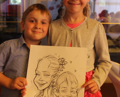 Rodzeństwo ze swoją karykaturą narysowaną na żywo przez rysownika Łukasza Szostaka